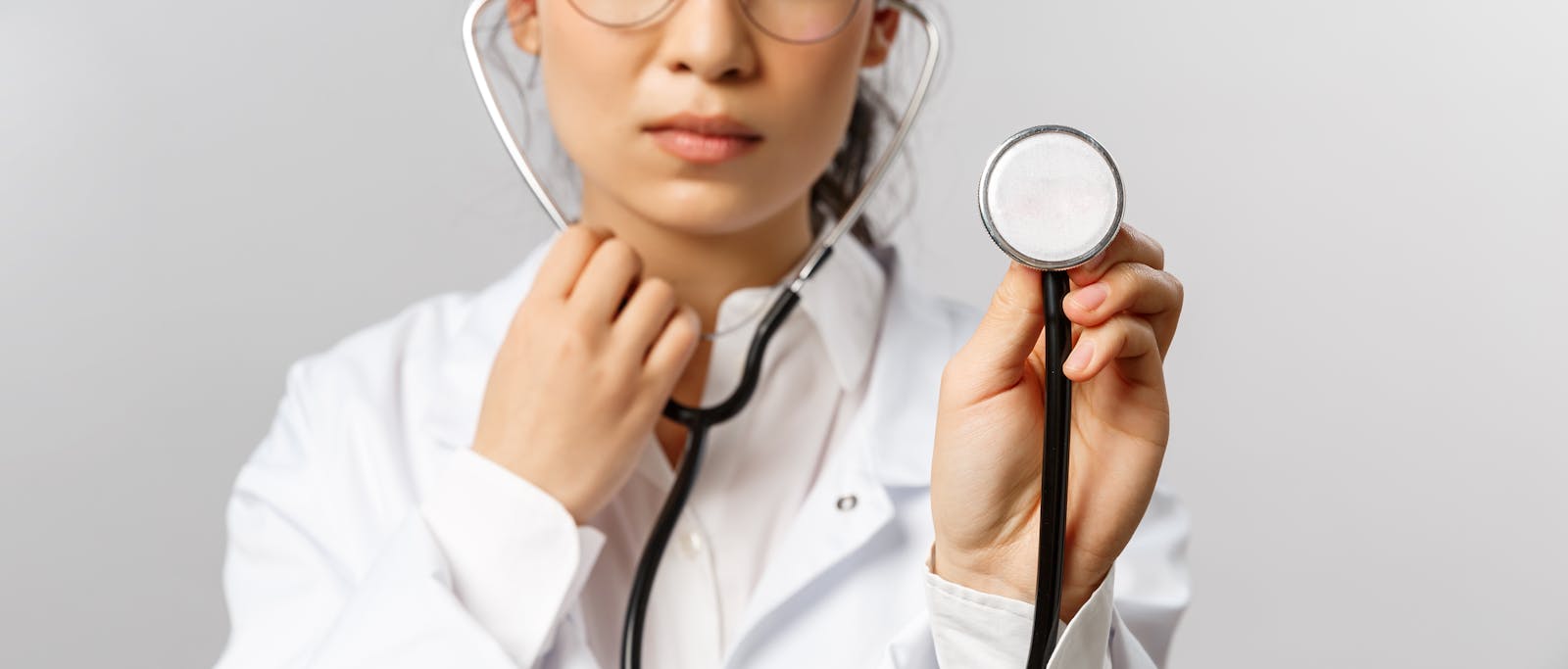 Woman Wearing a Lab Coat Using a Stethoscope